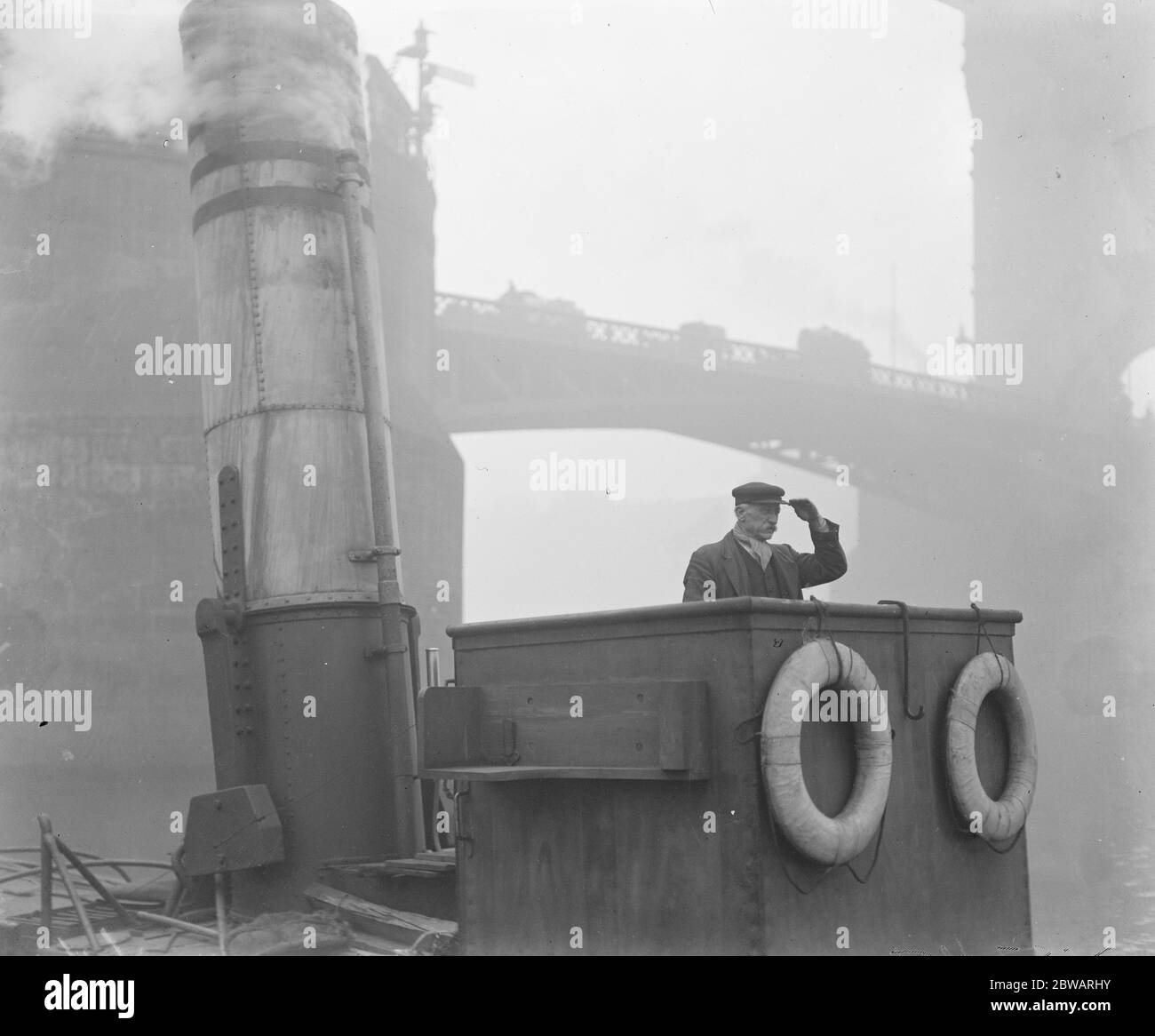 Guard tug which has kept watch for 20 years Steam tug ' Wasp ' at Tower Bridge Captain Partletton on the bridge of the Wasp 26 November 1919 Stock Photo