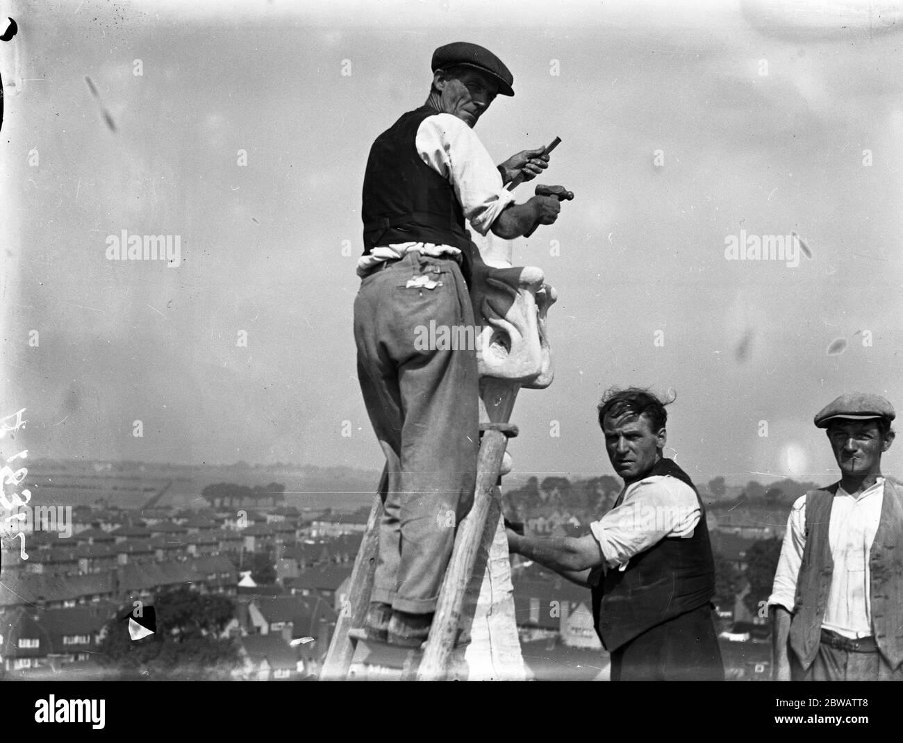 Steeplejacks at work on the 150ft high steeple of the new church of St Barnabas , Eltham , formerly the Old Dockyard Church at Woolwich . This new church has been re-erected brick by brick . 29th August 1933 Stock Photo