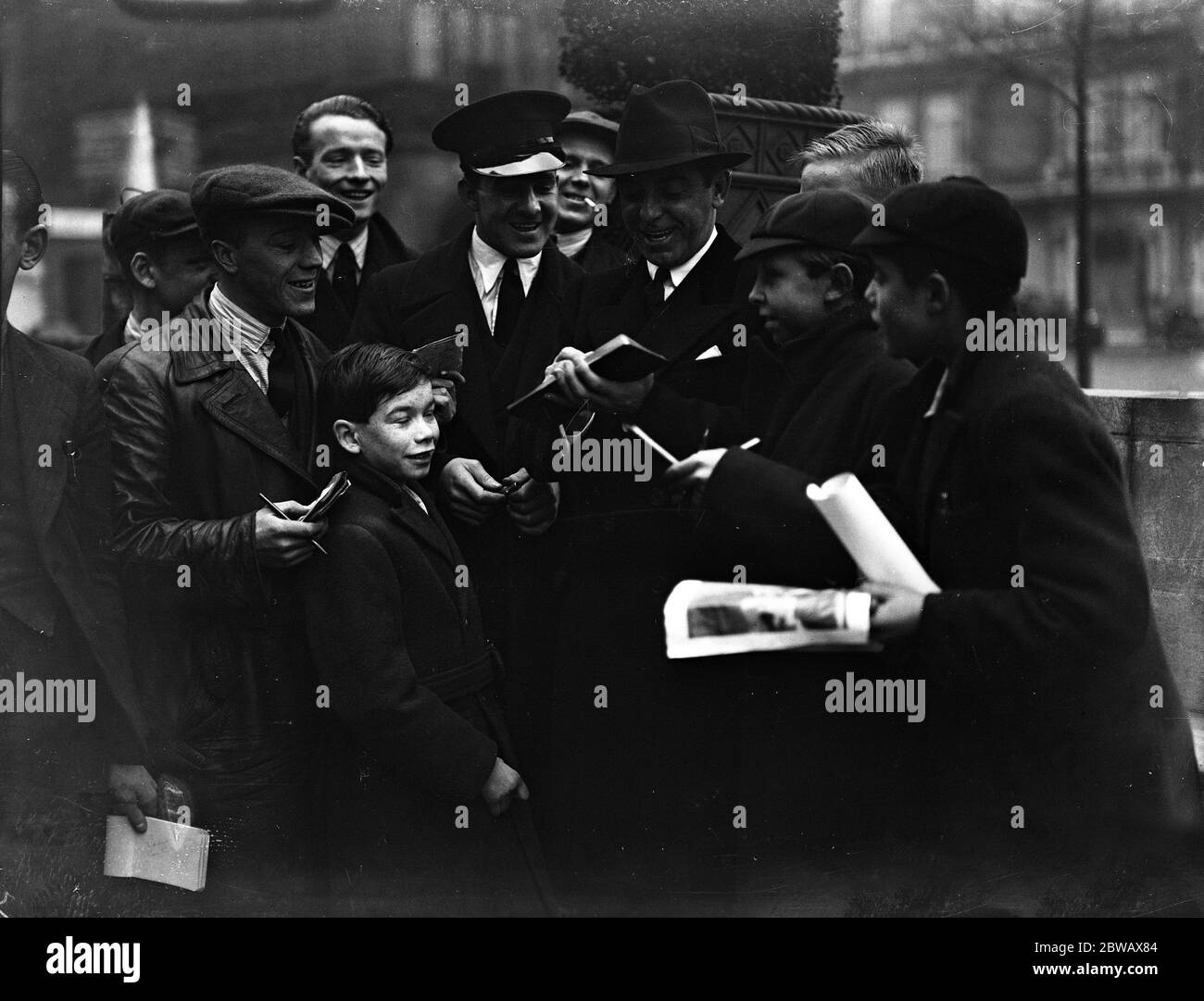 American entertainer , Eddie Cantor , signing autographs for his fans in London . 1935 Stock Photo