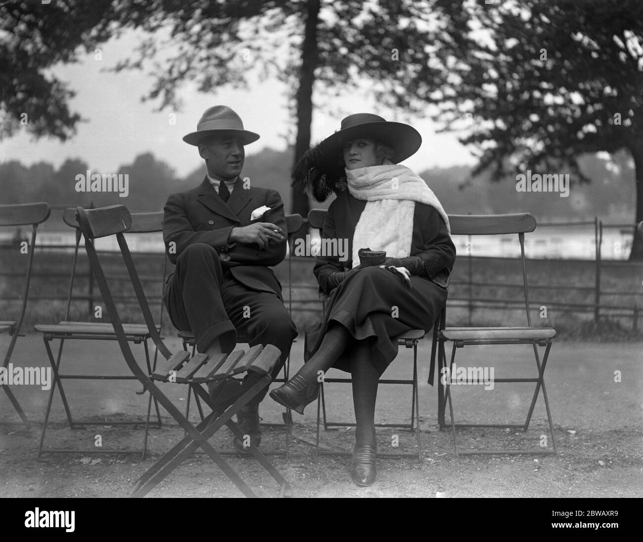 Mme Peletier with her husband sitting in Hyde Park , London . She is an English woman who has found fame as a cinema star in France . 26 June 1921 Stock Photo