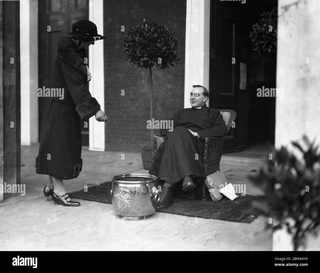 Reverend J W Woodhouse , vicar of St John ' s Church , Waterloo Road , receiving donations in the porch of his church . 24 October 1924 Stock Photo