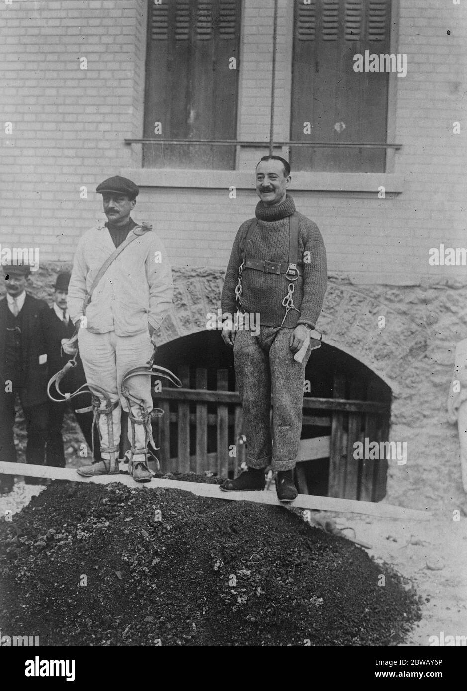 Monkey like climbing with monkey apparatus . The new apparatus and the old outfit worn by another workman . 13 May 1921 Stock Photo
