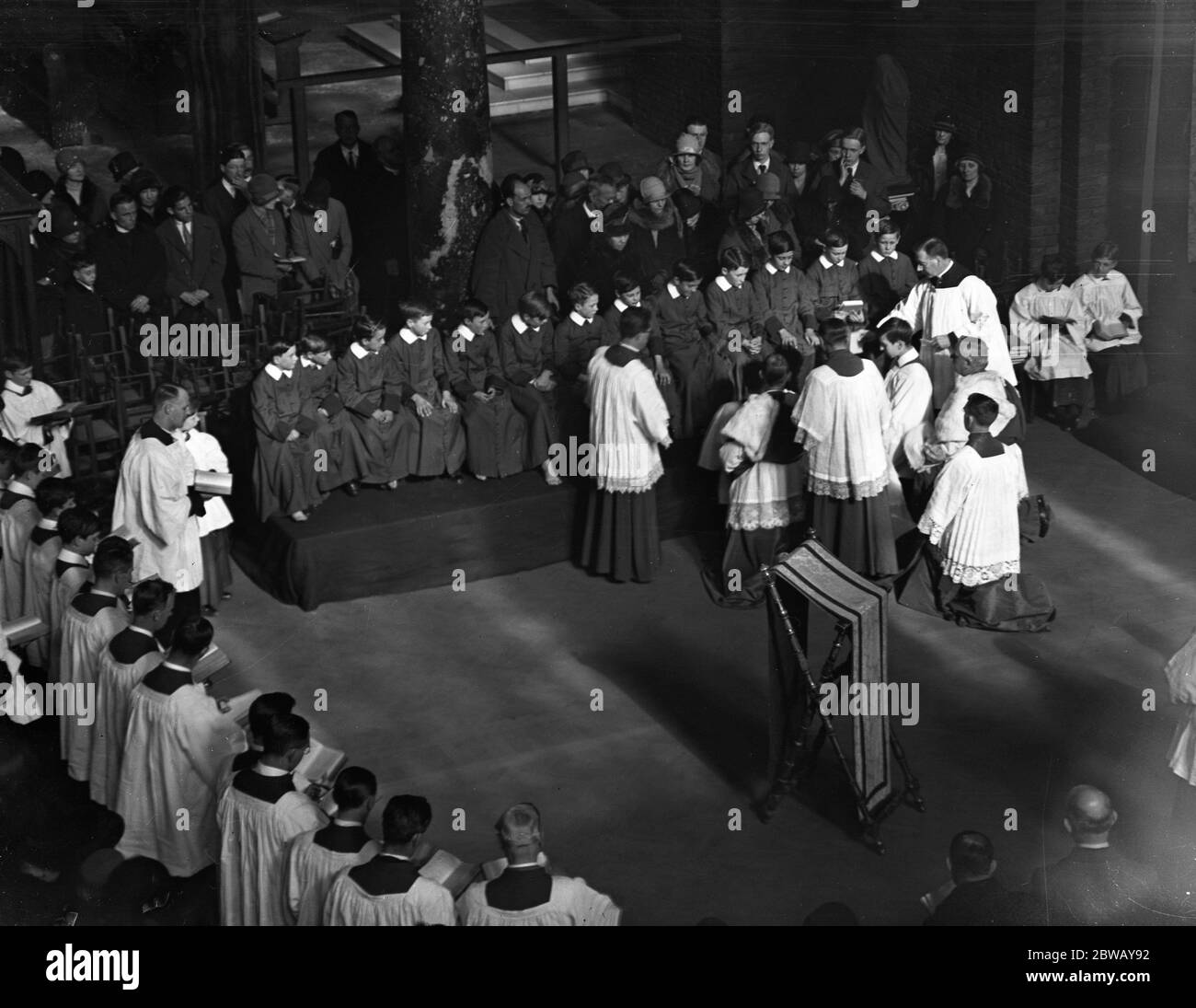 At Westminster Cathedral , Cardinal Bourne , in accord with ancient custom , washing the feet of small choirboys , as an act of humility . An Eastertide ceremony . 5 April 1928 Stock Photo