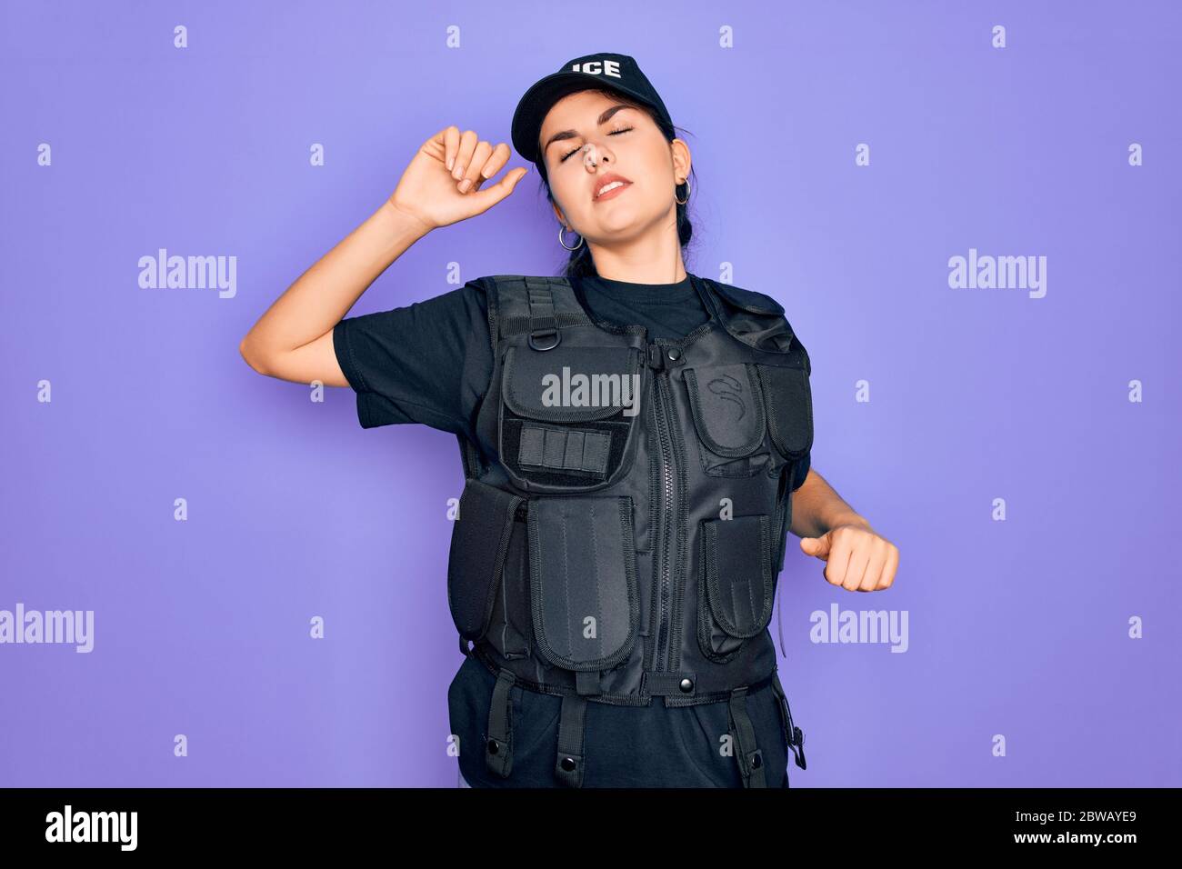 Young police woman wearing security bulletproof vest uniform over ...