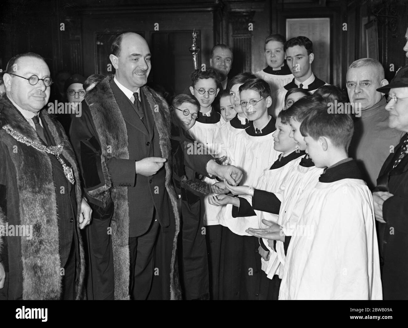 Captain Ambrose Keevil , renter warden , makes the distribution of the Poulters shilling to choirboys of St Peter - upon - Cornhill Church , an Ash Wednesday custom dating from 1609 . 22 February 1939 Stock Photo