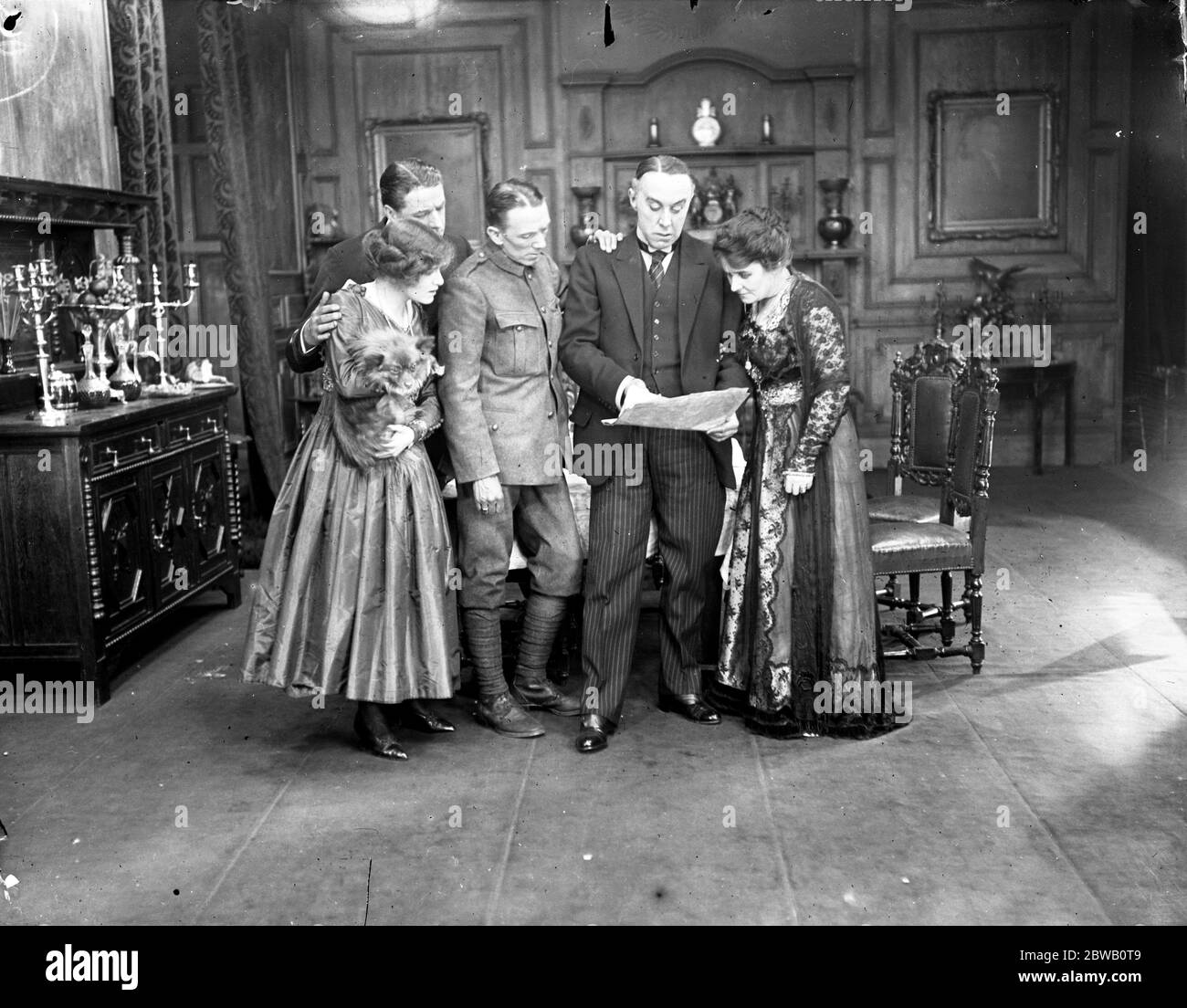 A scene from ' Everybody ' s Business ' , a food economy film . Left to right ; Miss Renee Kelly , Mr Matheson Lang . Mr Gerald Du Maurier , Mr Norman KcKinnel and Miss Kate Rorke - reading the food controllers proclamation 1917 Stock Photo