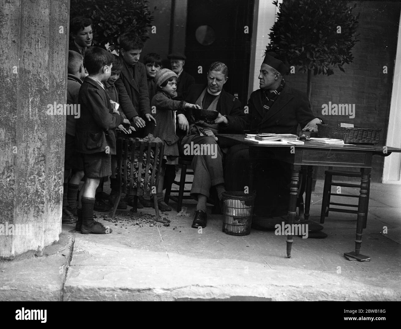 The Reverend C W Hutchinson , vicar of St John ' s Church , Waterloo Road , London , during his 12 hour vigil in the church porch , when he received donations for the church . Receiving gifts to clear the debts on the church bells , restored after 20 years to commemorate the jubilee . 5 January 1935 Stock Photo