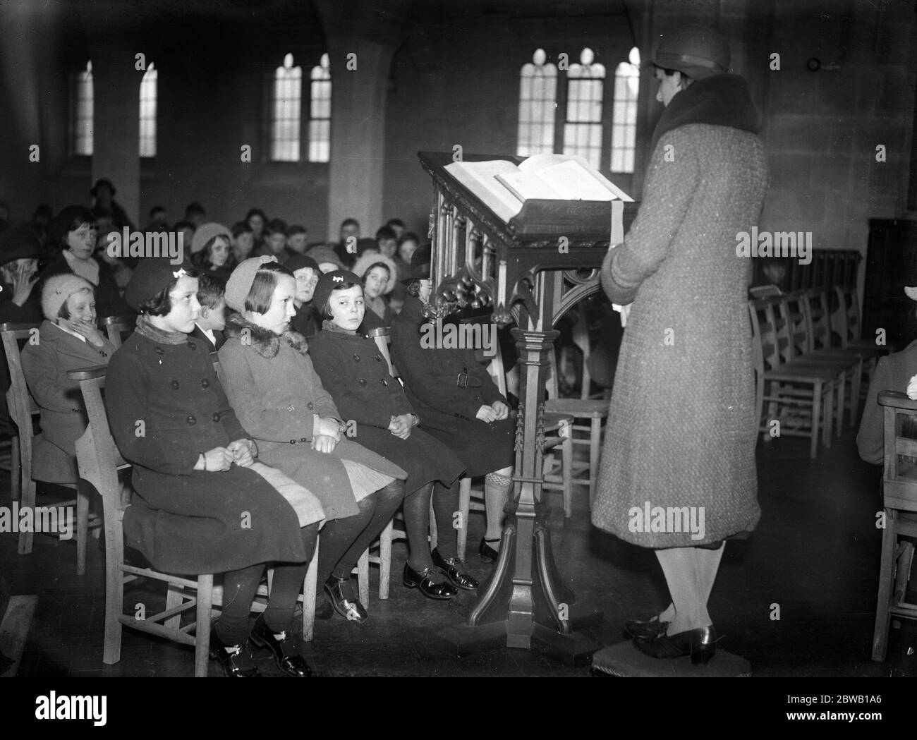 Once a month a children ' s service is conducted by the small worshippers themselves . It is held at St Paul ' s Church , Egham Hythe , Surrey . The vicar and sidesmen being elected by themselves . Here the young congregation listen to a reading . 1 March 1936 Stock Photo
