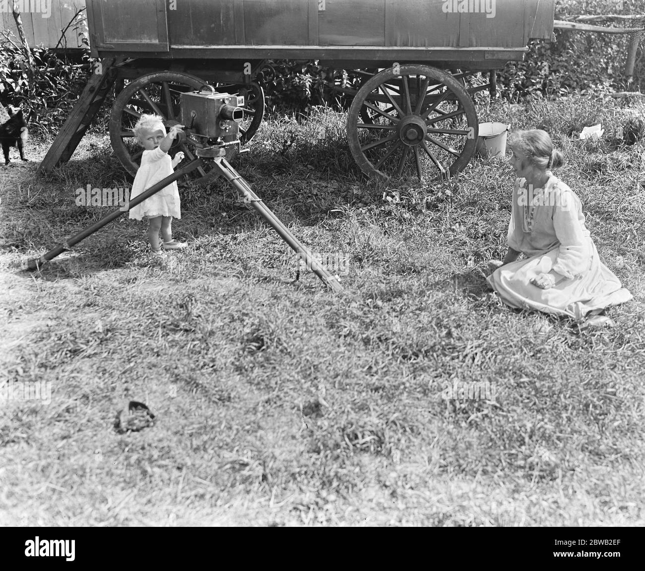 Two families unable to find accomodation in London , have hired a caravan and tents and are camped on the river bank in Staines . Baby interested in the cinema camera 13 August 1919 Stock Photo