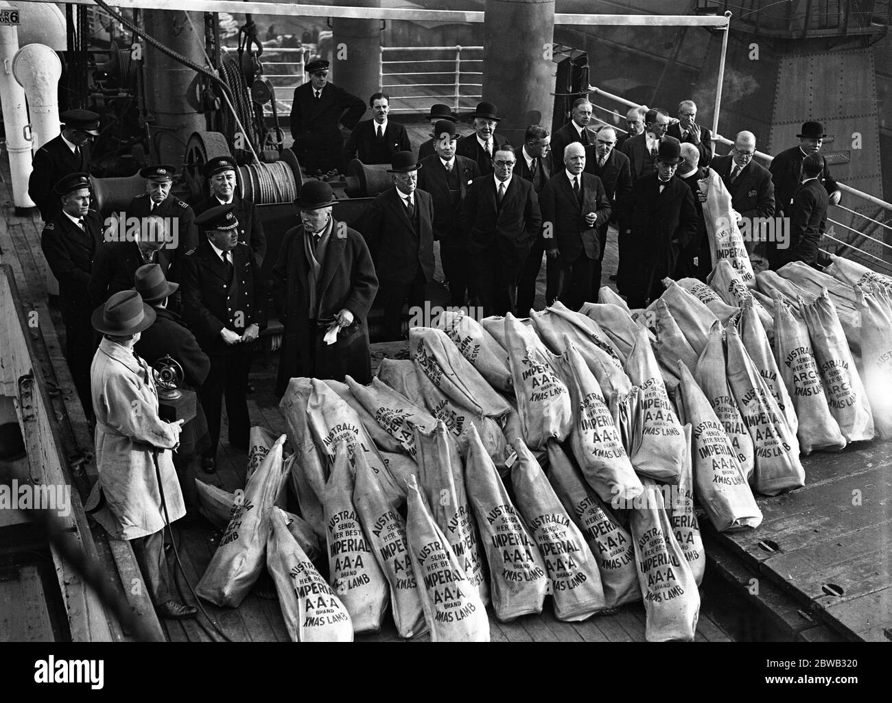 Empire produce at the Royal Albert Docks , London . 4,000 lambs sent by Australians to friends in this country , arrived at the Royal Albert Docks aboard the , ' SS Large Bay ' . Pictured far left in this group is Captain W M Jermyn of the Aberdeen Line with Sir Granville Ryrie , High Commissioner of Australia . 8 December 1931 Stock Photo