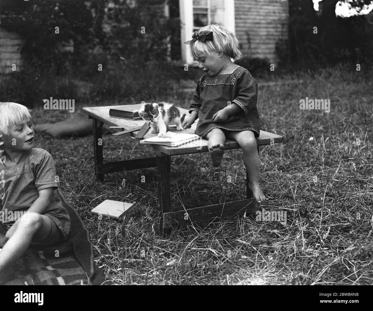 The Kosmon or Faithists Community at Eggbuckland Devon . A little girl plays with her kitten . Stock Photo