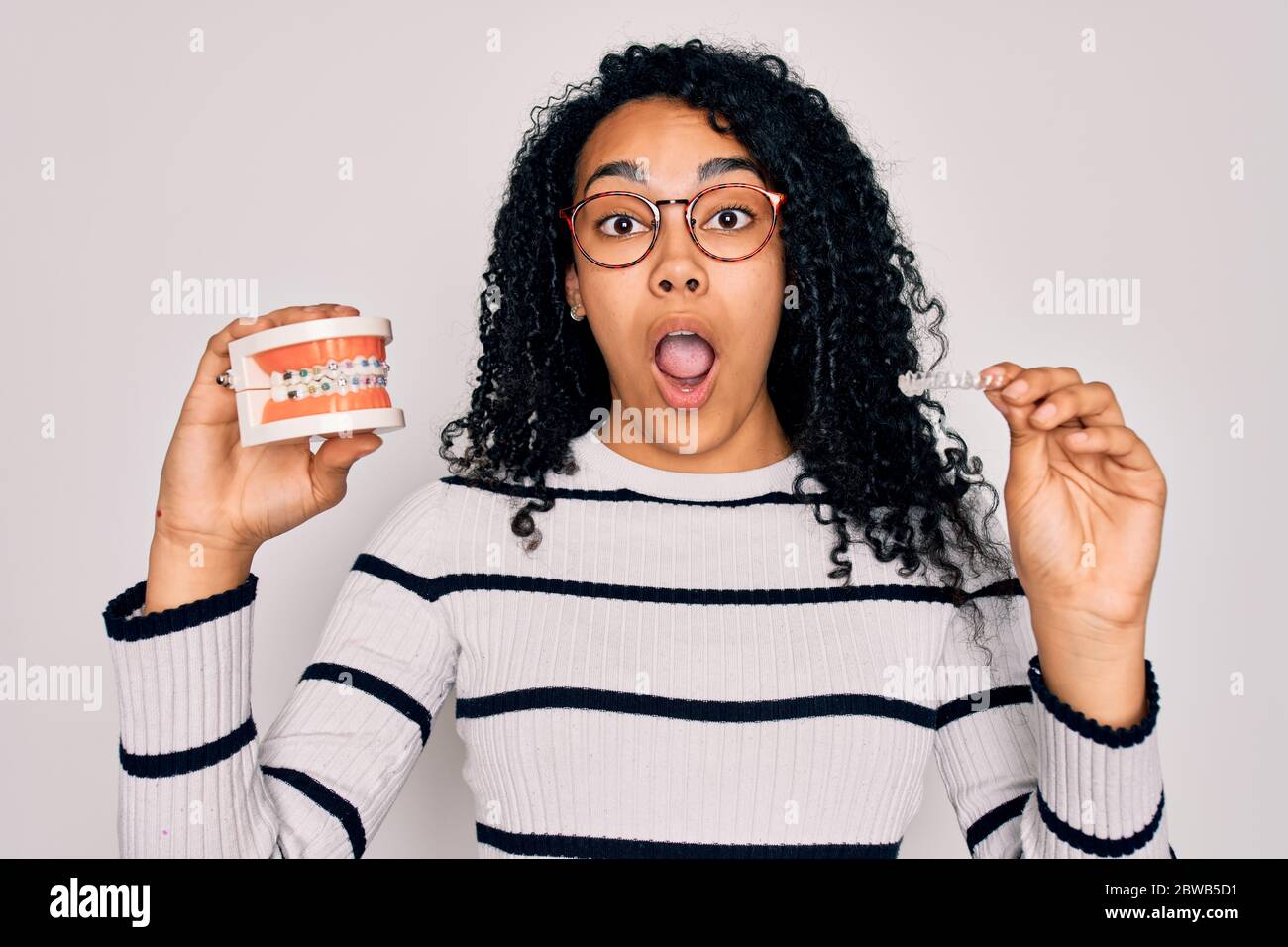 Young beautiful african american woman with curly hair wearing glasses ...