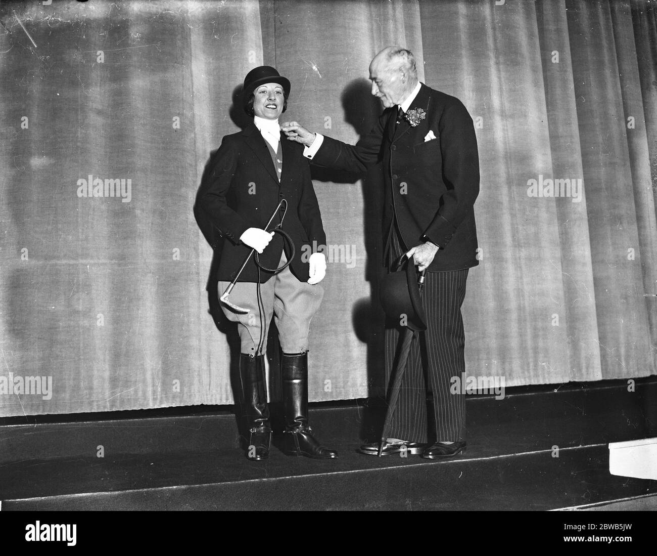 Sir Walter Gilbey acts as arbiter of correct wear for riding astride , when he attended a mannequin at the British Industries Fair at the White City , London . 26 February 1934 Stock Photo