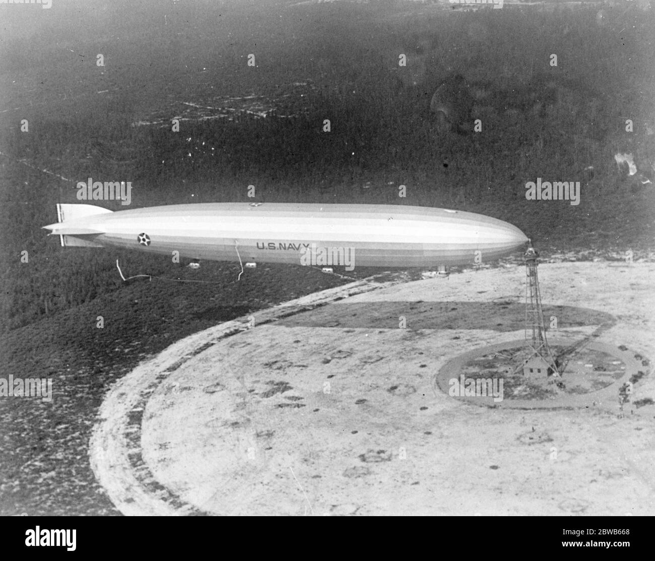 Just a few moments before the airship ' Shenandoah ' sailed away for its transcontinental trip . An usual picture of the giant ' Shenandoah ' , showing it attached to its mooring mast at Lakehurst , New Jersey , before it sailed away for its transcontinental trip . 15 October 1924 Stock Photo