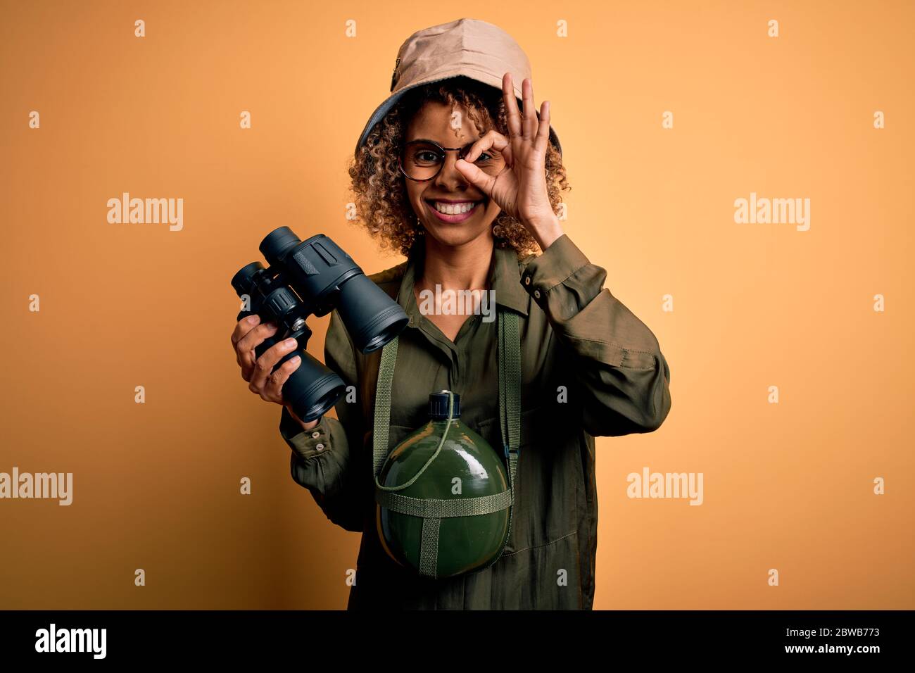 African american tourist woman wearing explorer hat and water canteen ...