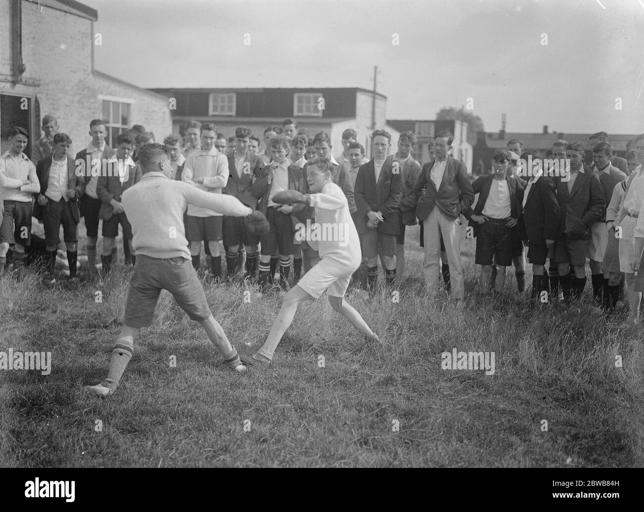 Boys from public schools and factories at Duke of York ' s camp , New Romney , Kent An impromptu sparring match between campers 3 August 1924 Stock Photo