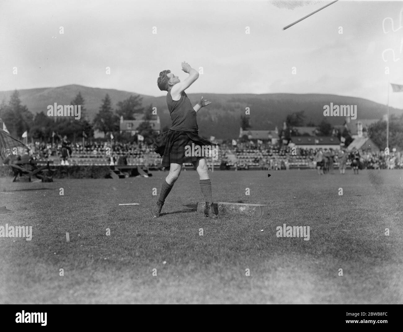 King and Queen at Braemar gathering . A fine action study of Ian Grant , winner of the hammer throwing . 7 September 1923 Stock Photo