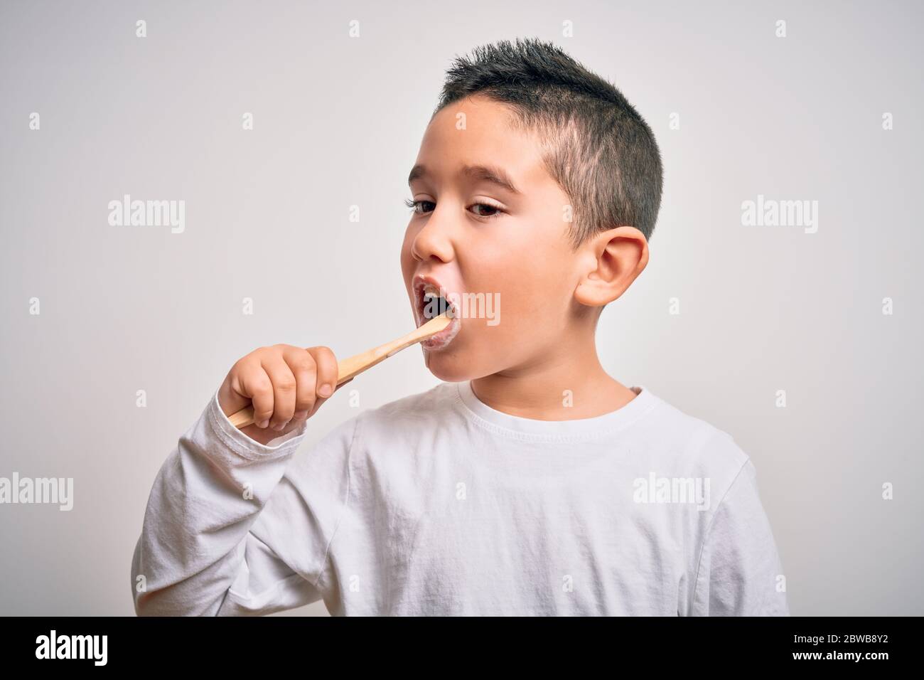 Young little kid boy brushing her teeth using tooth brush and oral paste, cleaning teeth and tongue as healthy health care morning routine. Learning d Stock Photo