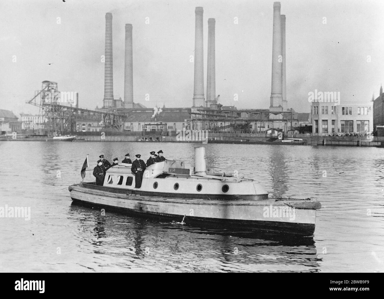 German State River police guard cable works . Work has been suspended at the Oberspree Cable Factory owing to a strike . The building is being guarded by the State River Police . State River Police patrolling before the Works . 3 November 1923 Stock Photo