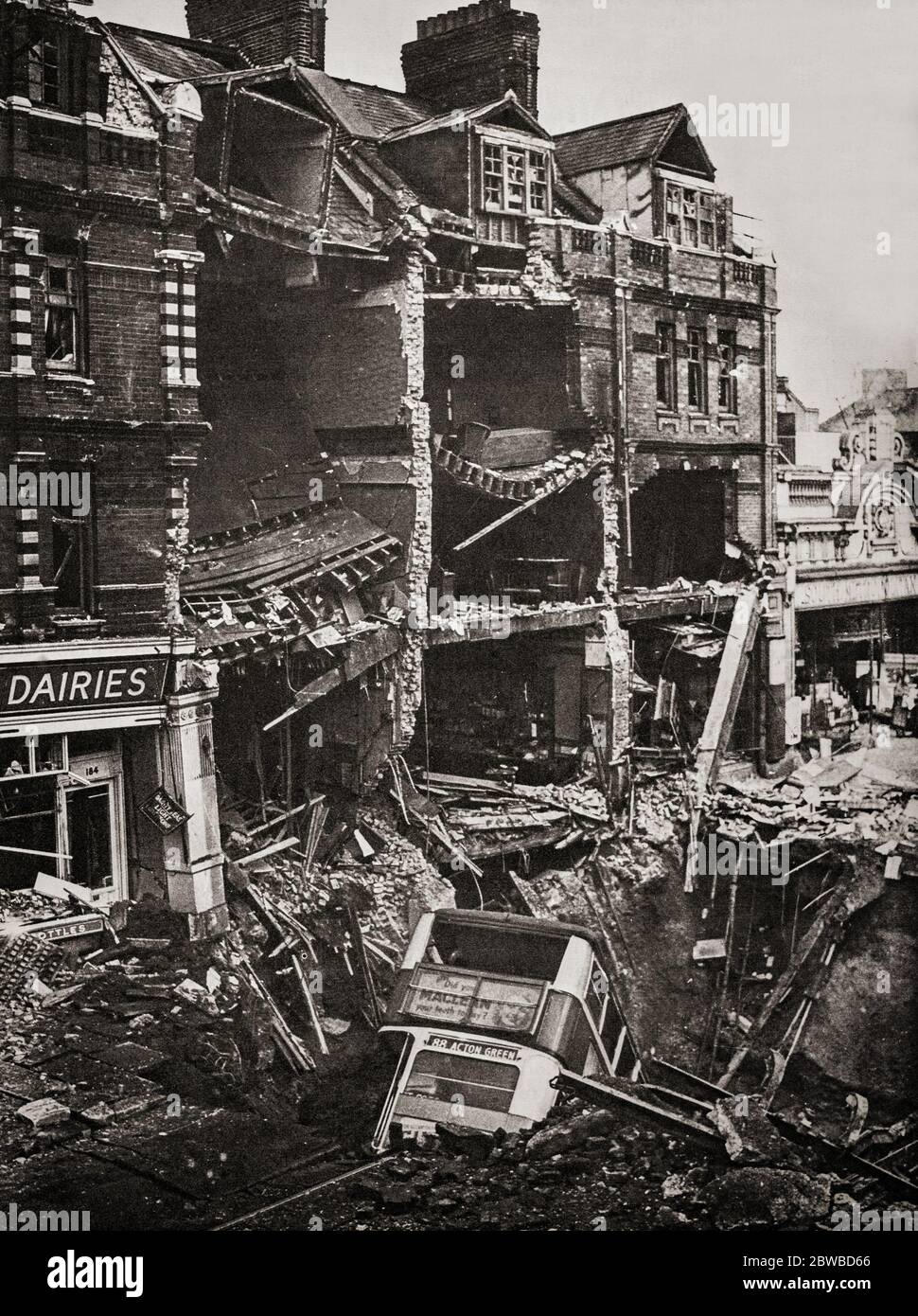 Following an air raid on London during the Blitz German bombing campaign against the United Kingdom in 1940 and 1941, during the Second World War, a bus in a huge bomb crater. Stock Photo