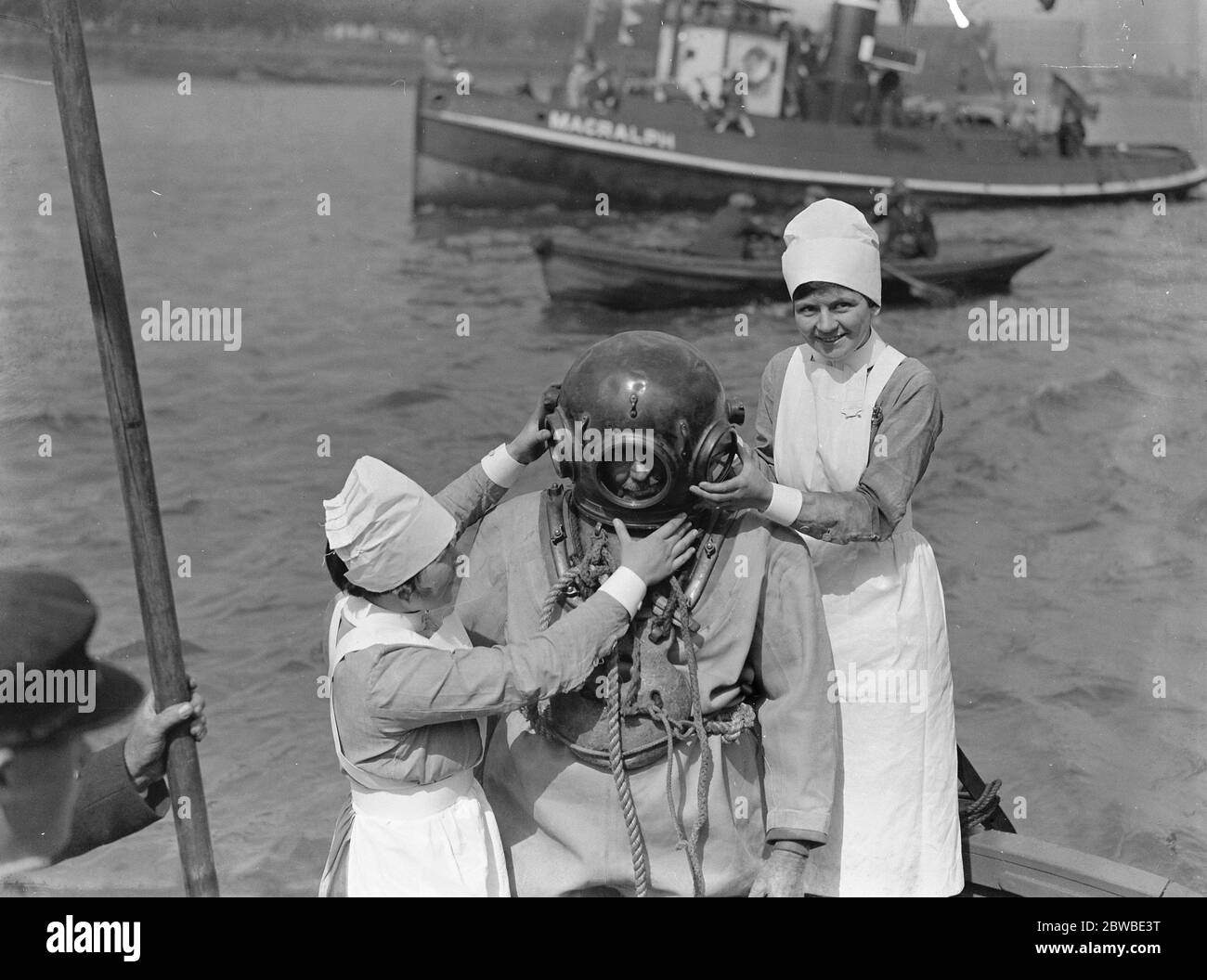 Fixing a diver 's helmet ( at Greenwich Seamen 's Recatta ) . 4 August 1930 Stock Photo