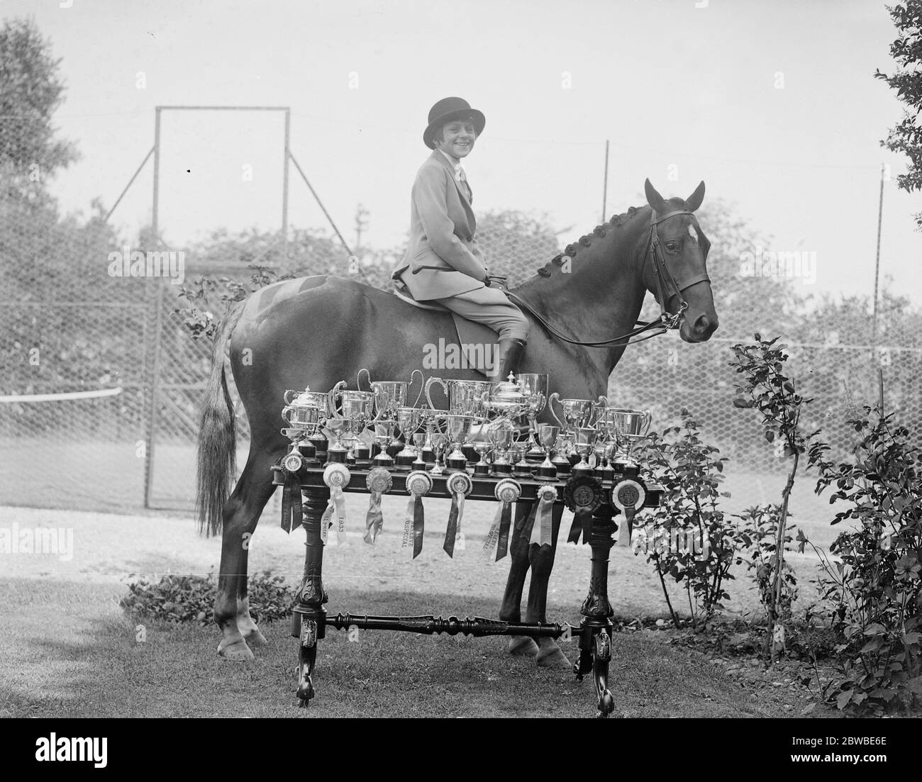 Miss June Lees Smith , the girl rider , and her pony ' Flash ' and the trophies they have won this season . They are here seen at her Aldershot home . 1933 Stock Photo