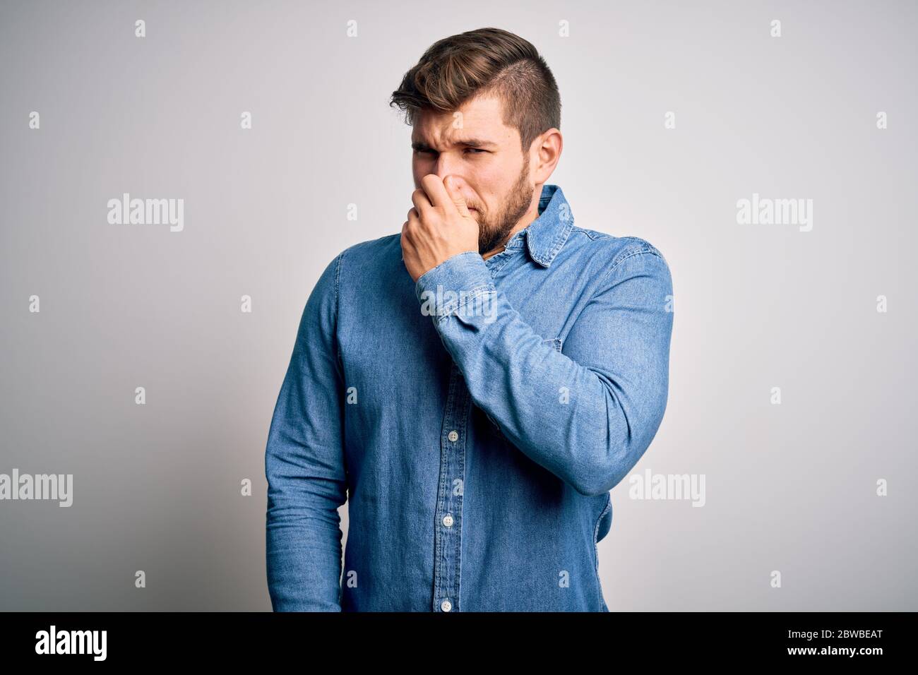 Young handsome blond man with beard and blue eyes wearing casual denim ...