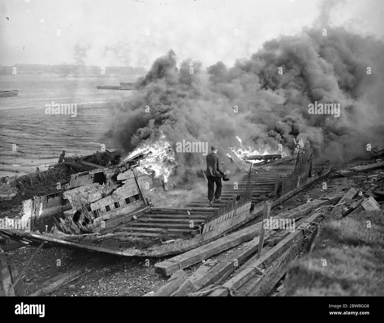 Graveyard of the Old Thames Barges After the Thames barges have served their period of usefulness on the river they are bought by the breakers and taken to a spot on the riverside near Belvedere and burned to the water ' s edge , The heavy bottom timbers and iron being saved and re-sold 8 December 1936 Stock Photo