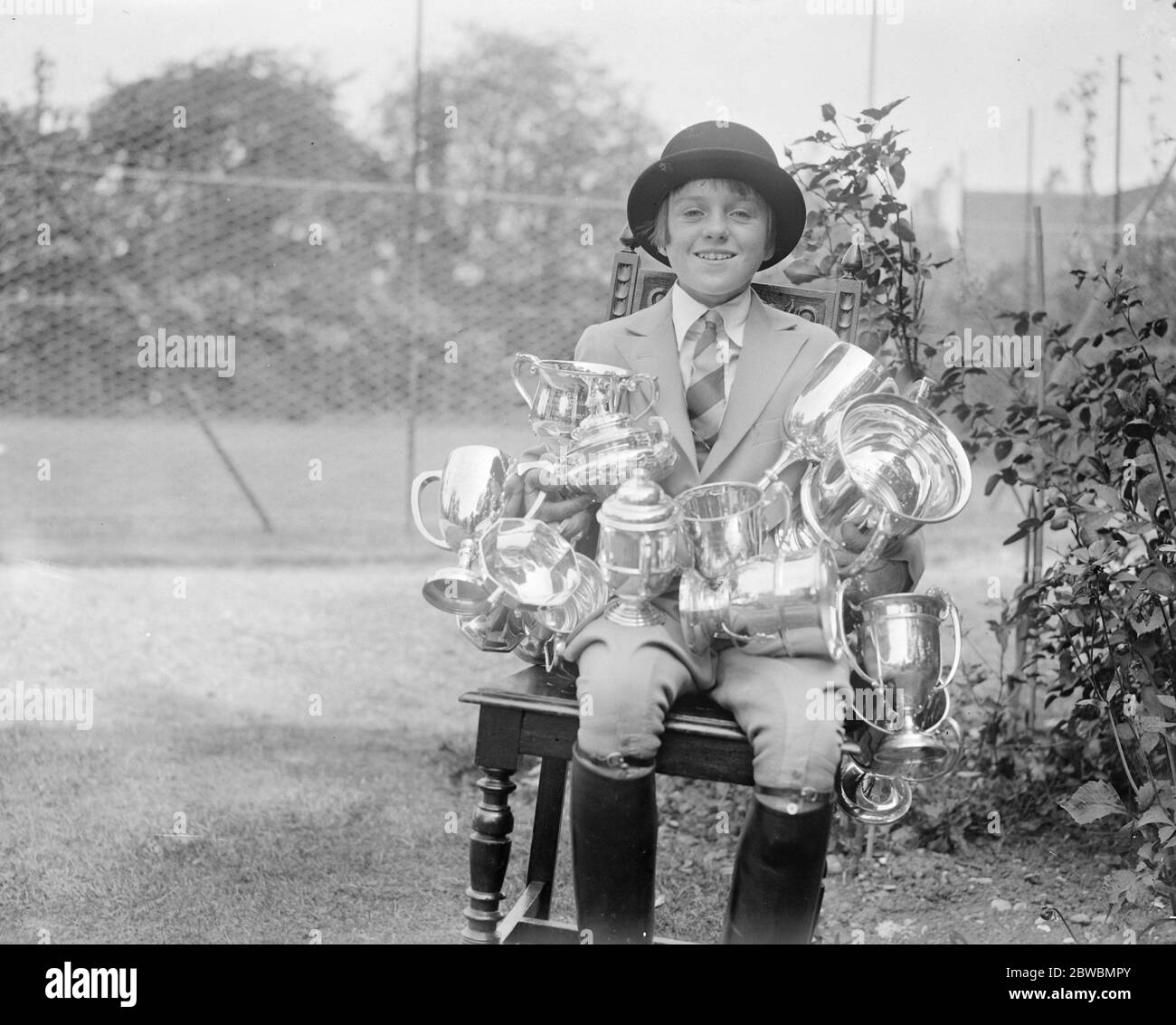 At her home Warrington house , Cranmore lane Aldershot Miss June Lees Smith the 11 year old girl rider , and and some the trophies she has won . In the past five years she has accumulated 150 trophies . she is the daughter of Major James Smith and niece of the right Hon H B Lees Smith this season . They are here seen at her Aldershot home . 1933 Stock Photo