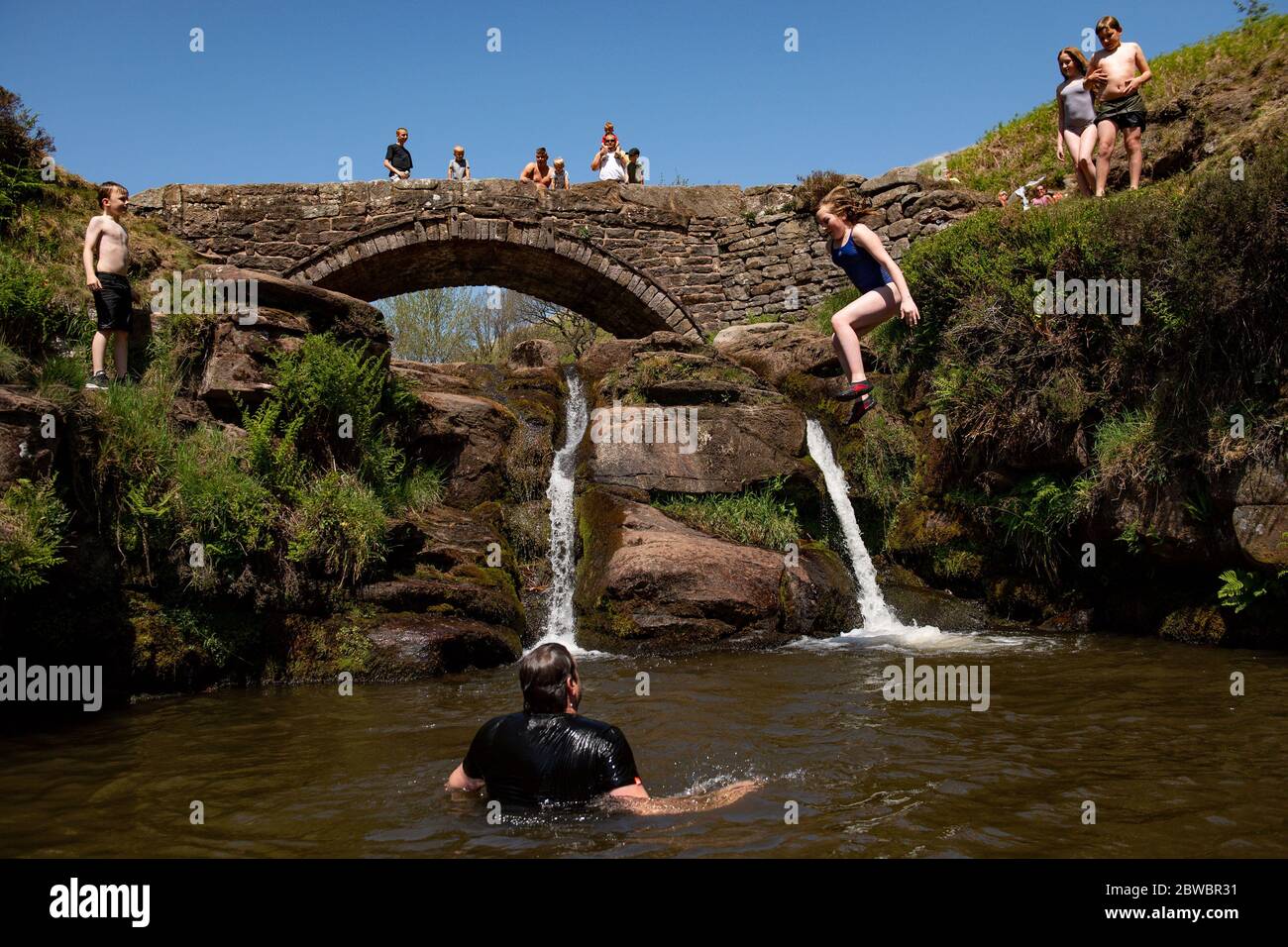 People enjoying the good weather by Three Shires Head on the River Dane, where Cheshire, Derbyshire and Staffordshire meet, as the public are being reminded to practice social distancing following the relaxation of lockdown restrictions. Stock Photo