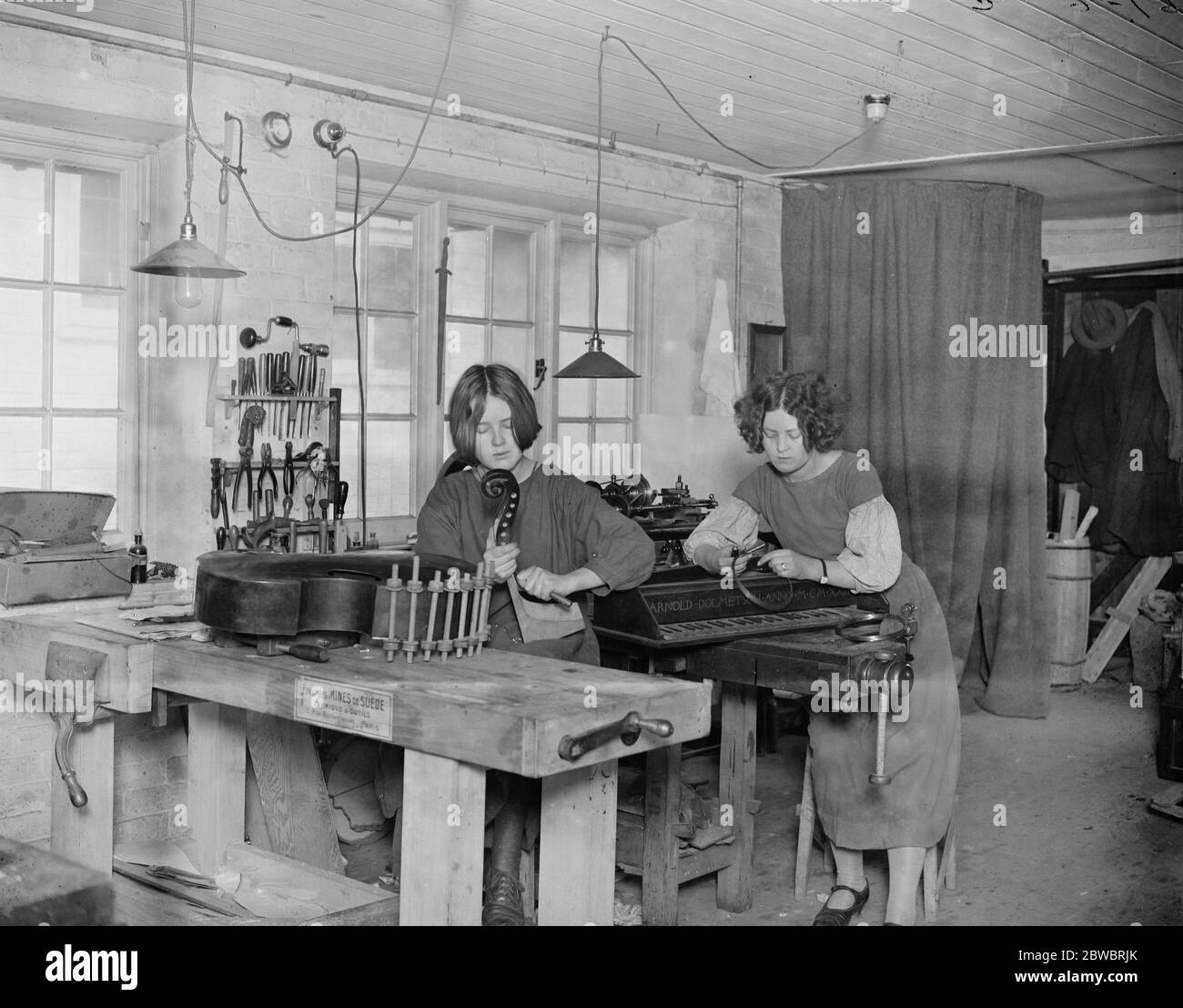 Preparing for Haslemere Festival of old chamber music . Famous family who make old time instruments . Two of Mr Arnold Dolmetsch 's daughters , Nathalie ( left ) and Cecile , in the workroom . 23 January 1925 Stock Photo