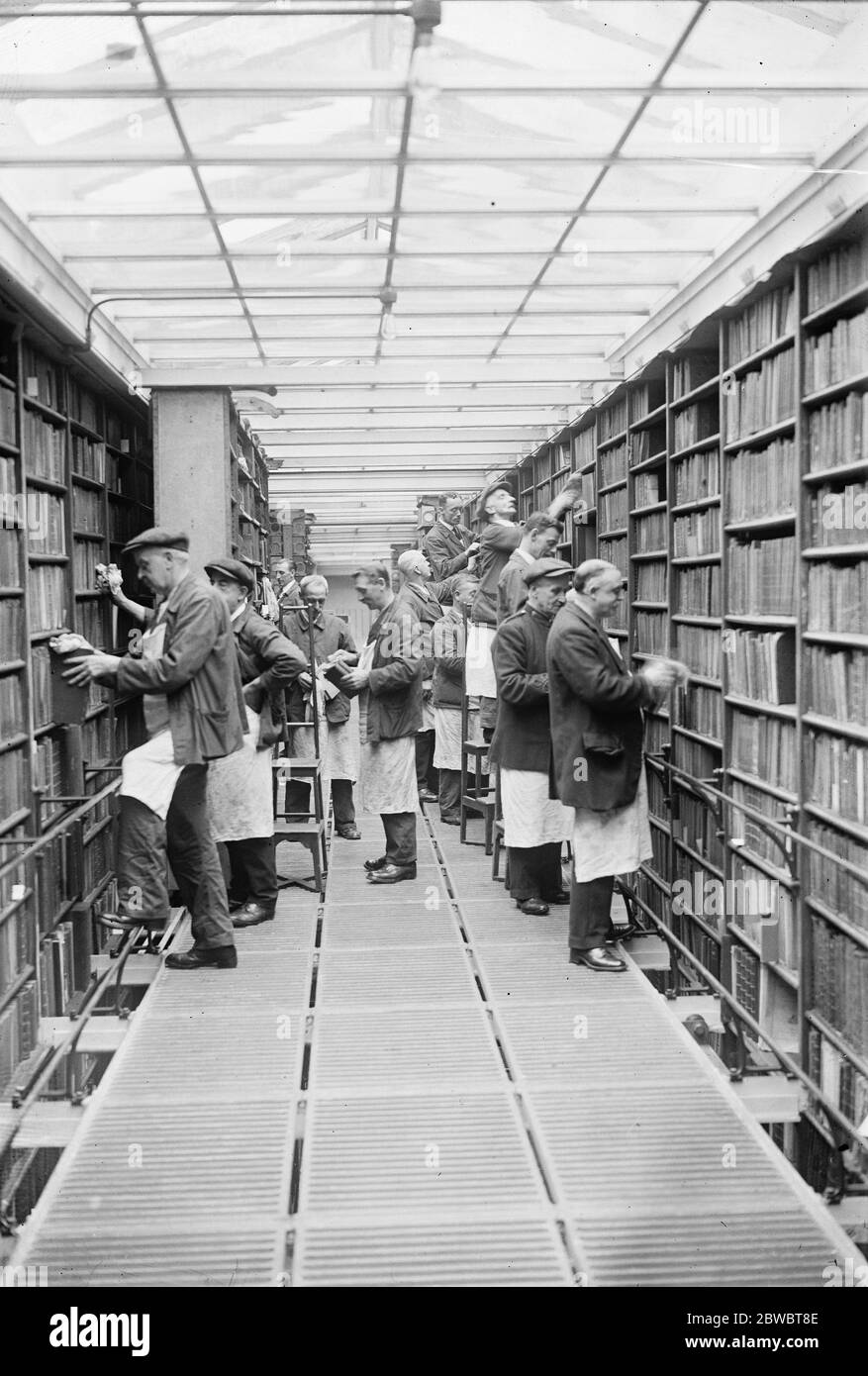 The gentlemen with the dusters . Millions of books being overhauled at the British museam Millionsof books in the iron room and reading room of the British museam are now being dusted , overhauled , repaired and checked 1 September 1924 Stock Photo