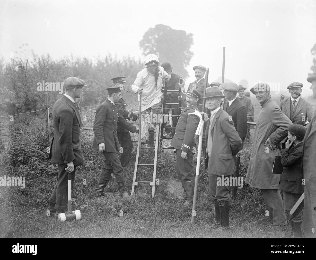 After 21 years , ancient custom of beating the bounds revived datchet Beaters of the bounds negotiating a hedge with the firemen ' s ladders which were carried in possession by members of the local Fire Brigade 30 September 1925 Stock Photo