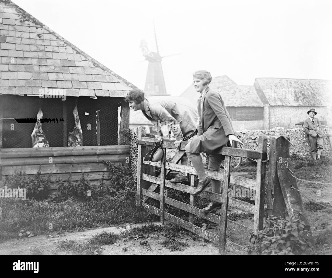 Brighton foot beagles hold meet at the kennels , West Blatchington . Keen feminie followers of hounds negotiate a five barred gate . 3 October 1925 Stock Photo