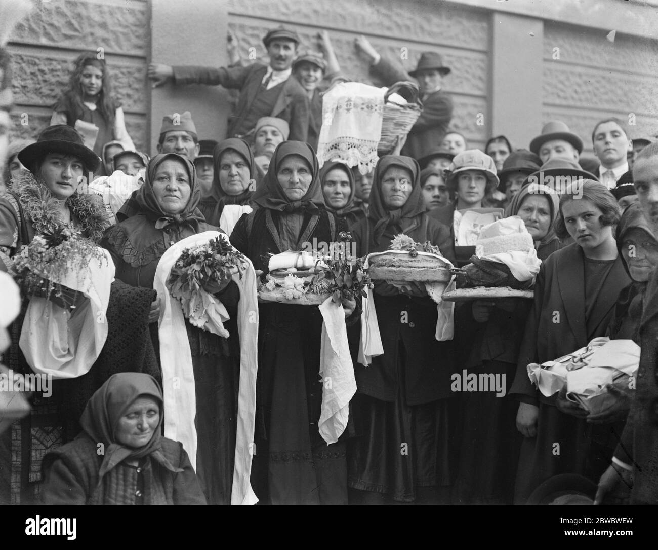 The future King of Serbia christened . Peasant women waiting at the gates of the Palace . They brought gifts of cooked fowl , meats , bread and lace for the infant Crown Prince . 24 October 1923 Stock Photo