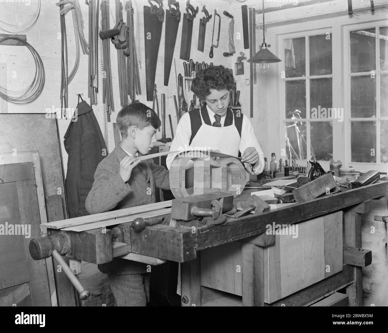 Preparing for Haslemere Festival of old chamber music . Famous family who make old time instruments . Rudolf Dolmetsch ( right ) and Carl Dolmetsch , sons of Mr Arnold Dolmetsch , in the workroom . 23 January 1925 Stock Photo