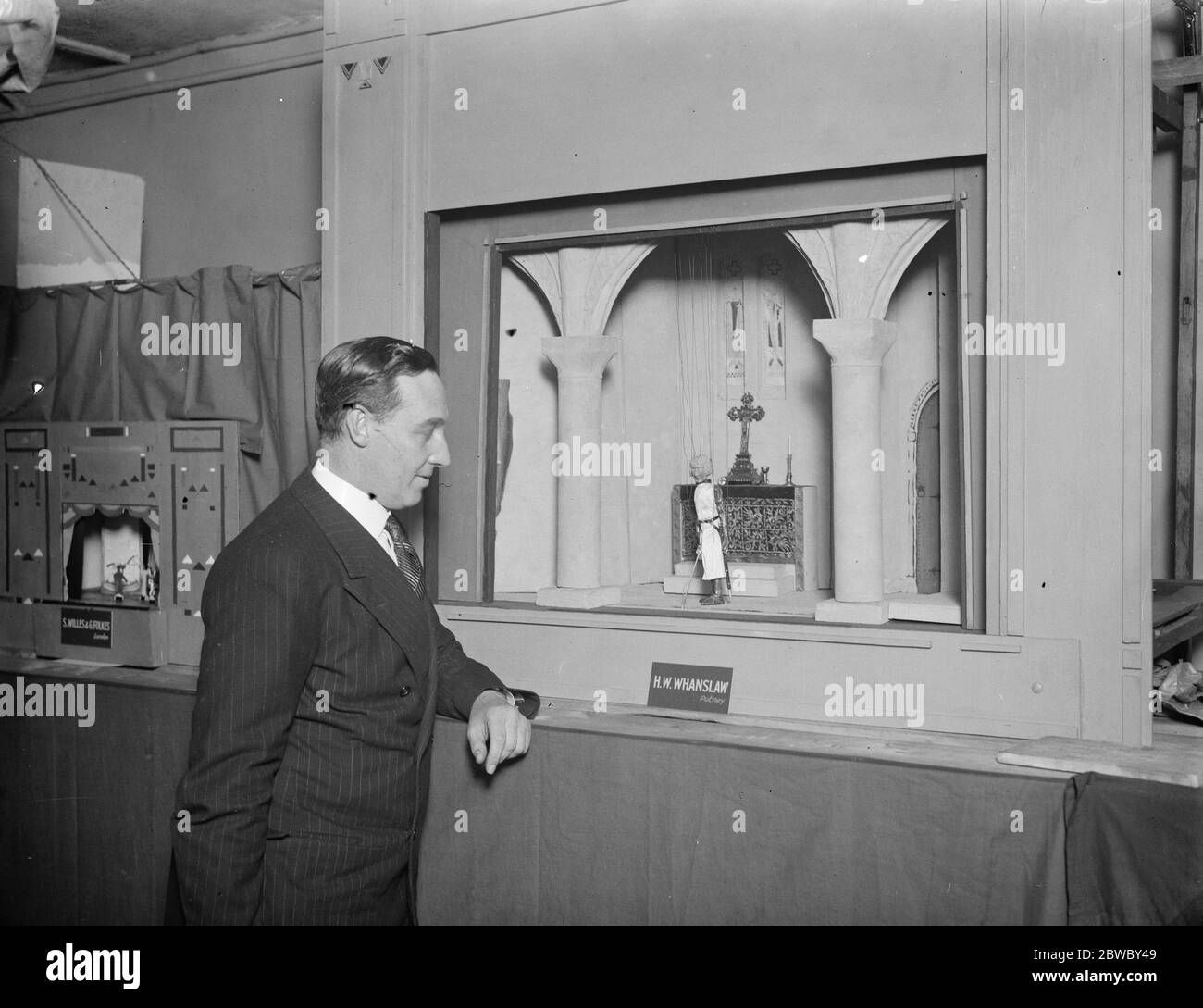 Sir Barry Jackson opens British model theatre guild ' s exhibition at Upper John Street . Sir Barry Jackson looking at the proscenium of the miniature theatre , made by Mr H W Whanslaw . The stage is set with a scene representing ' The Vigil ' in a twelfth century abbey . 6 April 1926 Stock Photo