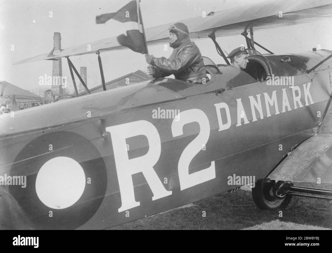 Danish airmen ' s flight to Tokyo . Danish airmen are now engaged in a flight from Copenhagen to Tokyo FLt Lt Hereschend is here seen placing the Danish flag on his machine just before the start . 23 March 1926 Stock Photo