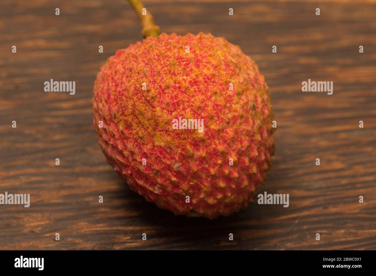 Close-up view of ripe lychee on black wooden background. Stock Photo