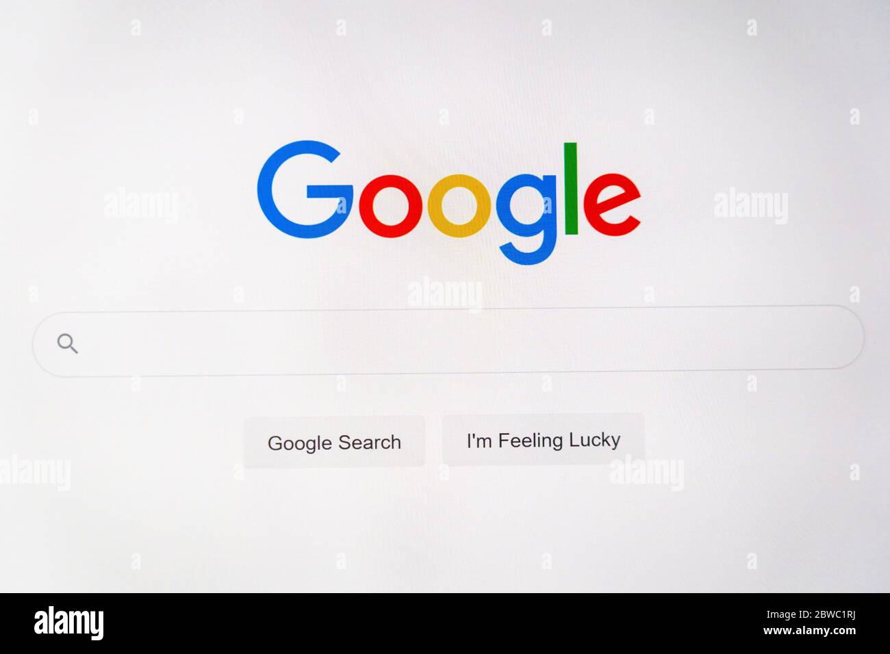 The Google homepage website with the Google logo, search bar and I'm feeling lucky button in the English language on a computer screen Stock Photo