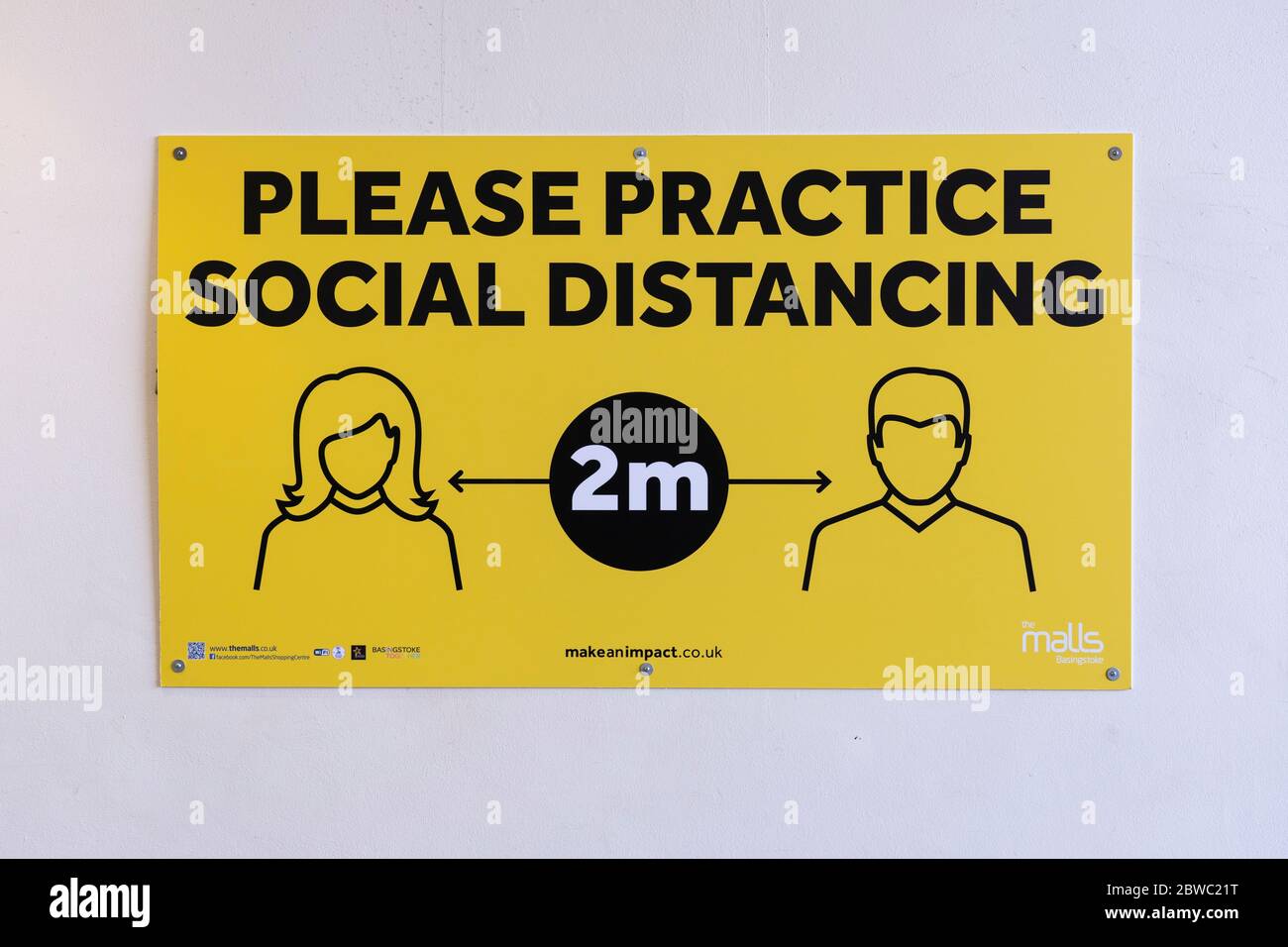 A sign in The Malls, Basingstoke, requesting that people practice social distancing and keep 2m distance during the Covid 19 Coronavirus pandemic, UK Stock Photo