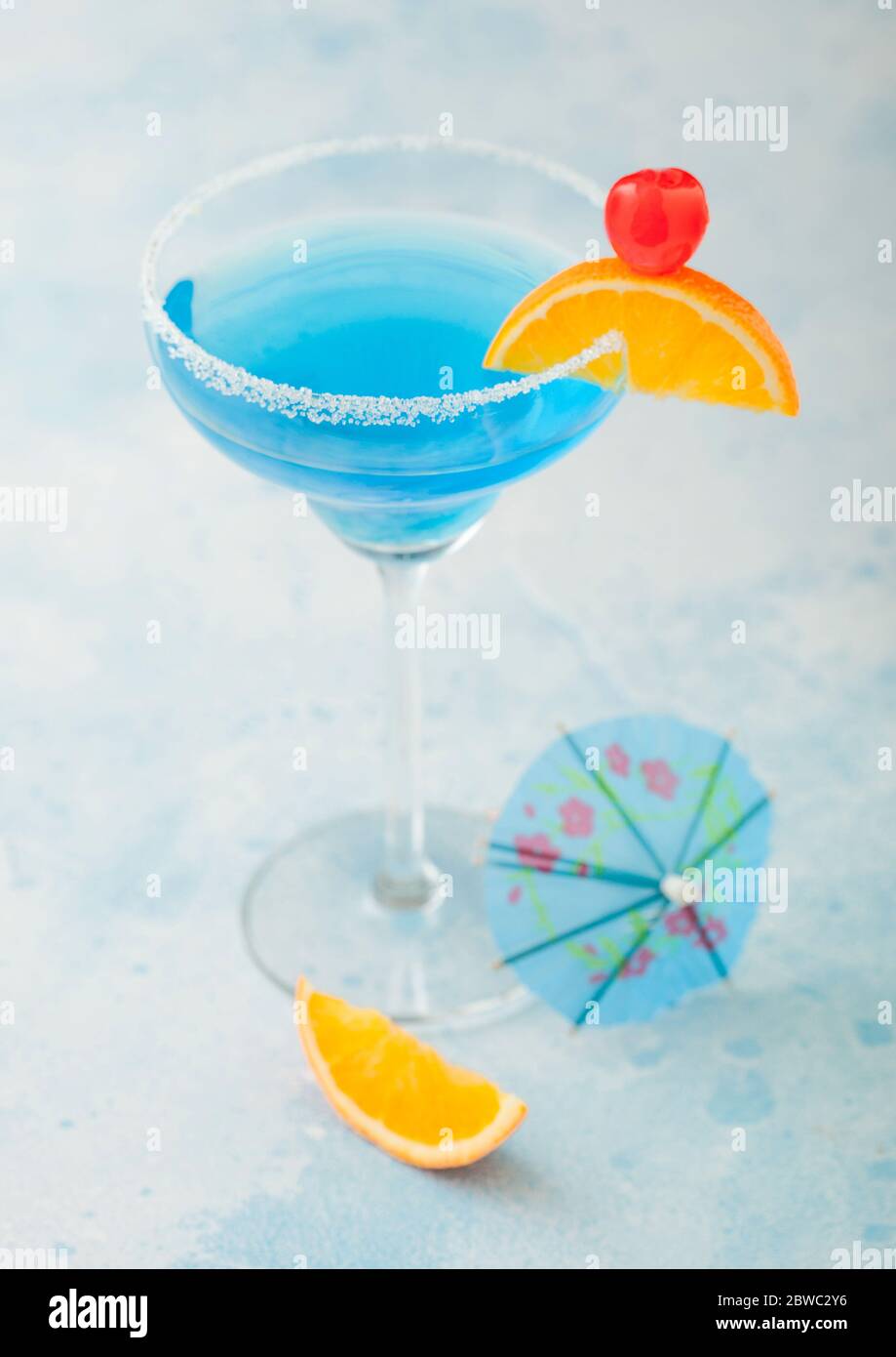 Blue lagoon summer cocktail in margarita glass with sweet cocktail ...