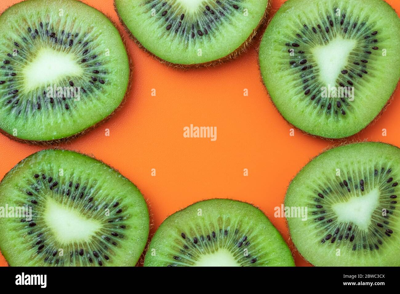 Kiwi fruit, tropical frame, food texture. Mockup with empty space, copy space for text. Summer background, orange pattern Stock Photo