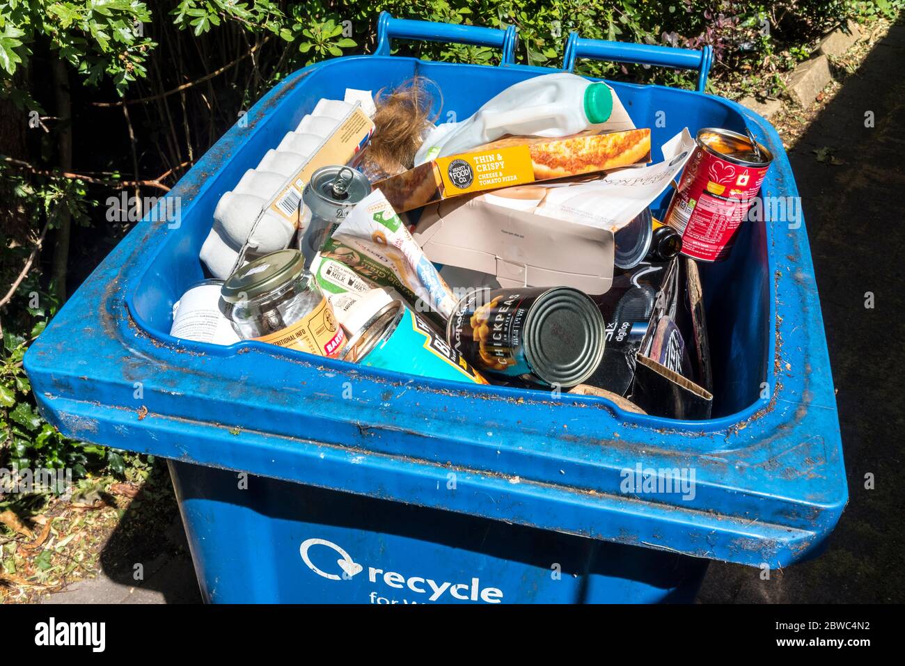 Blue bin recycling bin full of recyclable rubbish. Stock Photo