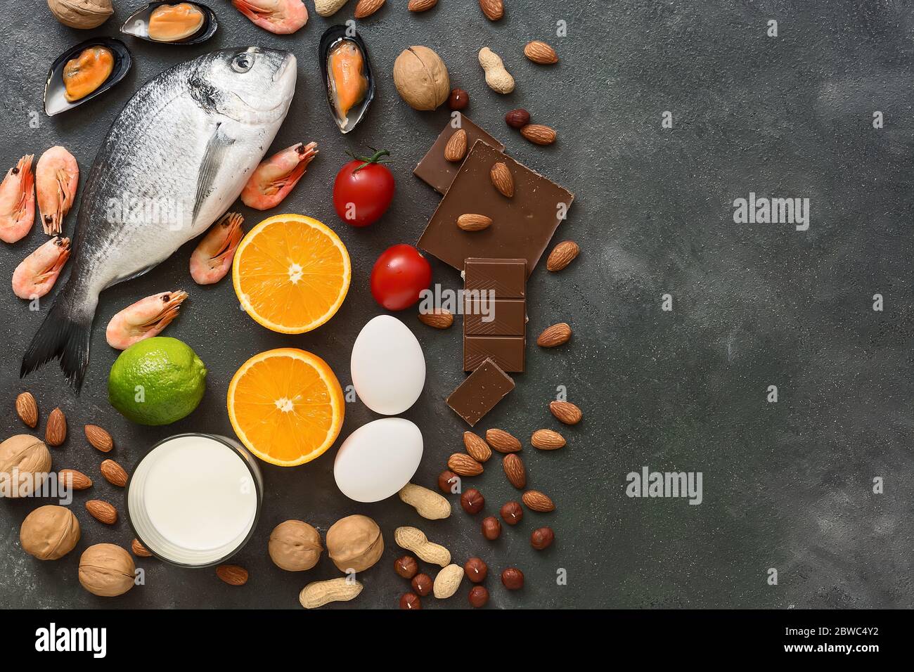 Food allergens. Seafood, milk, chocolate, nuts, citrus fruits, eggs. Allergic food concept. Top view, flat lay, copy space Stock Photo