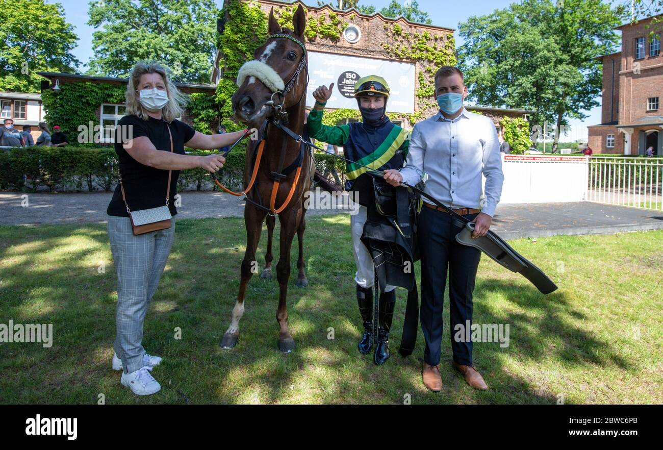 Hoppegarten, Germany. 31st May, 2020. Horse racing: Gallop, Hoppegarten Racetrack, second day of racing. Jockey Clement Lecoeuvre (2nd from right) is together with race horse Kalifornia Queen and owner Natascha Grewe (l) after winning the Röttgen Diana-Trial group race at Gestüt Röttgen. Due to the coronavirus pandemic, the races are held without spectators. Credit: Andreas Gora/dpa/Alamy Live News Stock Photo