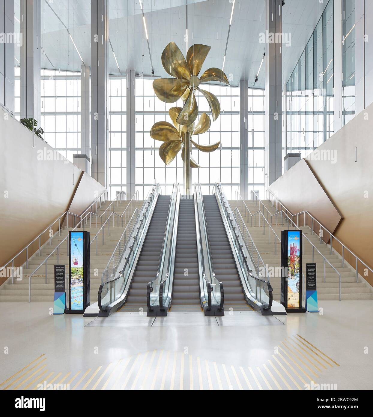 Interior view of escalators with sculptural propellor artwork. Royal Caribbean Miami Cruise Terminal, Miami, United States. Architect: Broadway Malyan Stock Photo