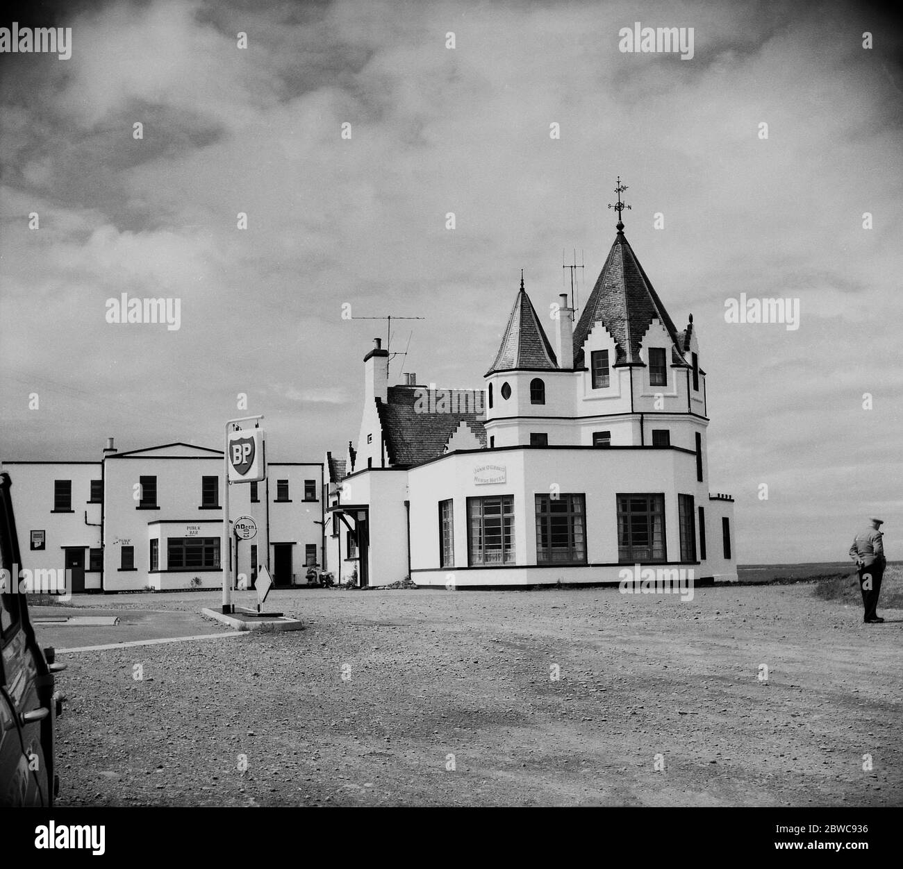1950s, historical, Exterior view of the John o'Groats House hotel, Canisbay, Caithness, Scotland, UK,  showing the building's distinctive shape, turrets and gravel surfaced car park with its own fuel refilling station.The iconic looking house of an octagon shape was built in 1875 near or on the site of the house of Dutchman Jan de Groot from whom the site takes its name, who in past times ran a ferry to the Island of Orkney charging a coin which became known as 'the groat'. Stock Photo