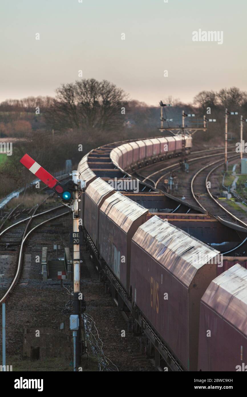 DB Cargo merry go round coal freight train passing the mechanical railway  semaphore signals at Barnetby, Lincs. the upper quadrant signal is 'off' Stock Photo