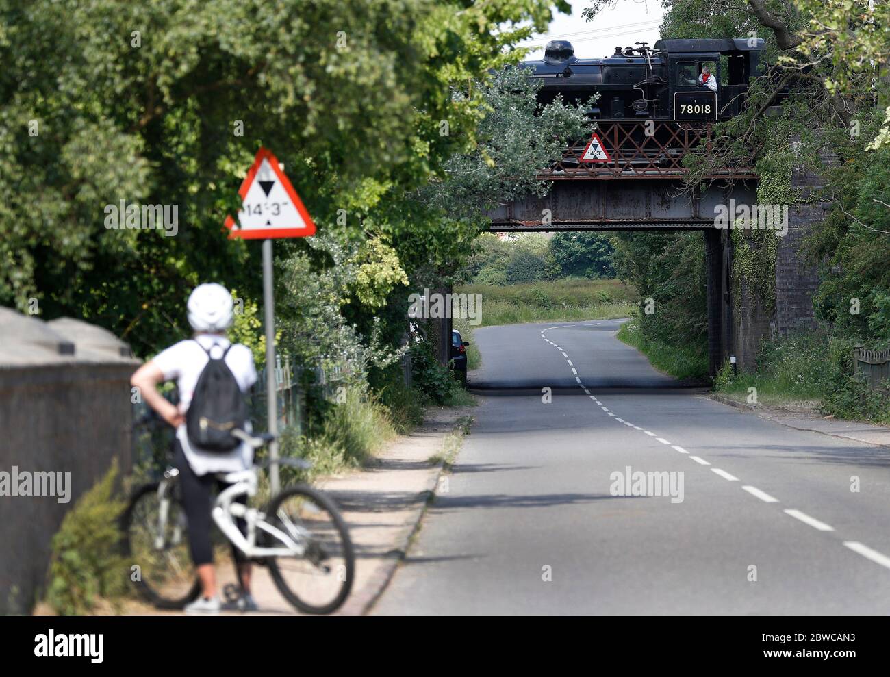 Loughborough, Leicestershire, UK. 31st May 2020. A cyclist stops to watch the testing of a Standard Class 2 locomotive steam train from the Great Central Railway after coronavirus pandemic lockdown restrictions were eased. Credit Darren Staples/Alamy Live News. Stock Photo